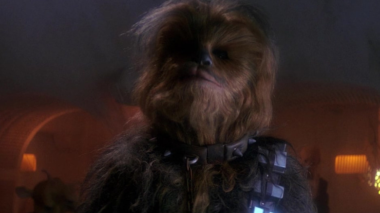 Peter Mayhew as Chewbacca with a chain around his neck in Star Wars: Return of the Jedi