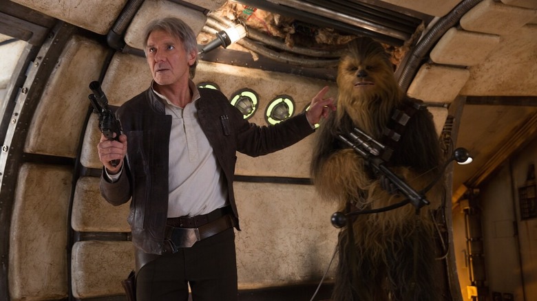 Harrison Ford as Han Solo and Peter Mayhew as Chewbacca entering the Millennium Falcon in Star Wars: The Force Awakens