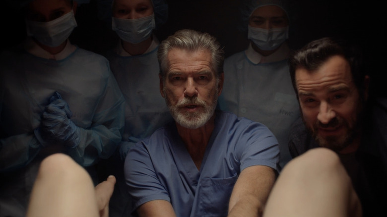 Pierce Brosnan's Dr. John Hindle is seen delivering a baby alongside Justin Theroux's Adrian Martin in False Positive