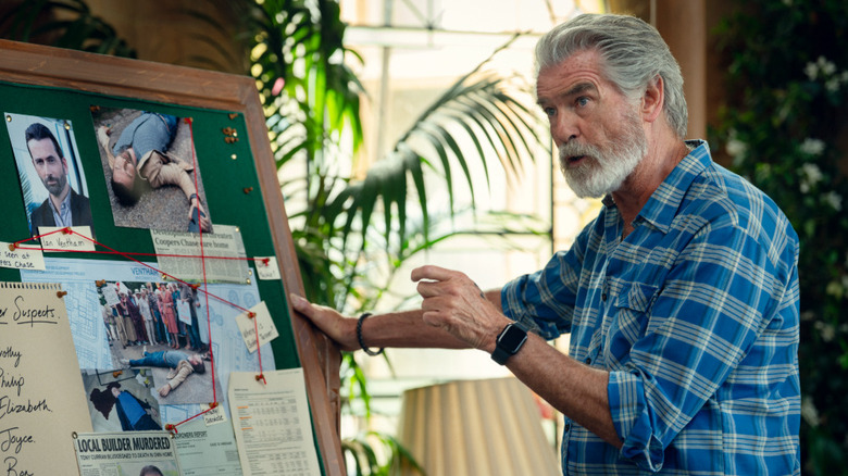 Pierce Brosnan's Ron Ritchie holding on to a clue board in The Thursday Murder Club