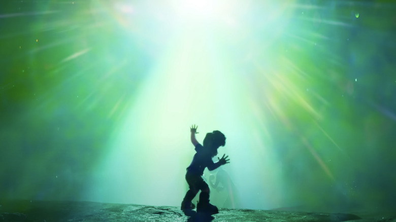 Elio stands in front of a glowing ray of green light