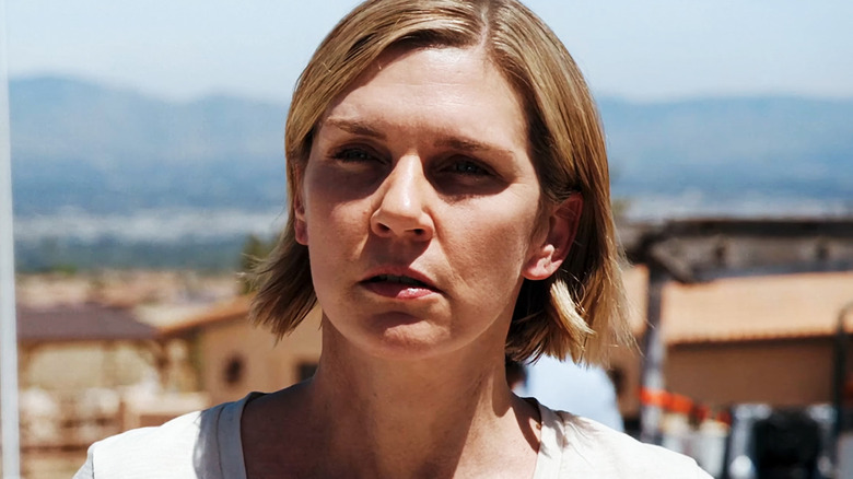 Rhea Seehorn as Carol Sturka stands outside in the direct sun in Pluribus