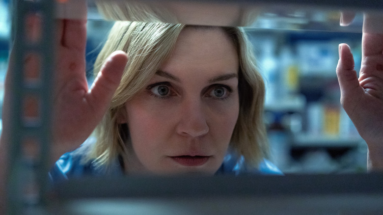 Rhea Seehorn's Carol Sturka looking at a shelf on Pluribus