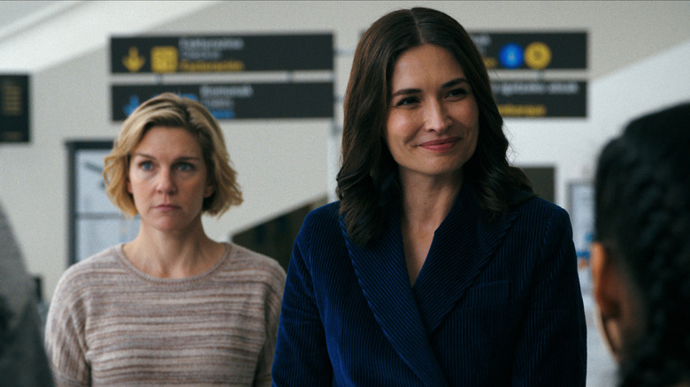 Rhea Seehorn as Carol Sturka and Karolina Wydra as Zosia standing next to each other at an airport in Pluribus
