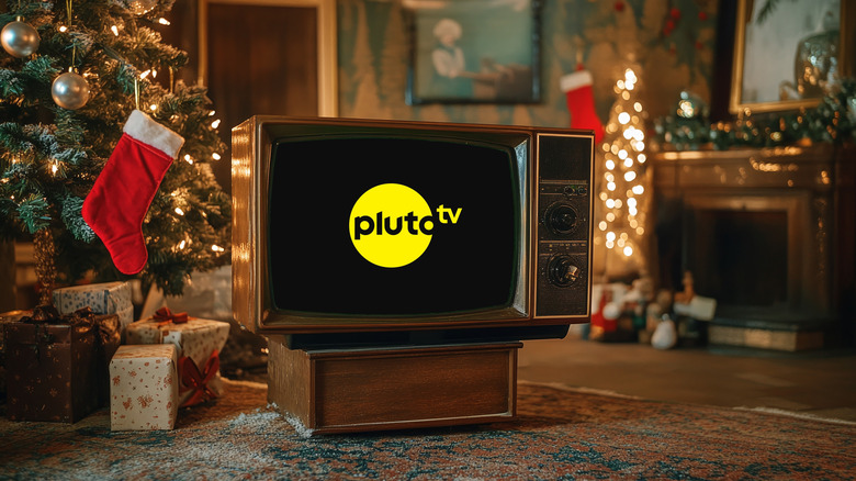 A television in front of a Christmas decorated living room with Pluto TV on the screen