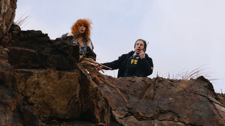Natasha Lyonne as Charlie Cale and Simon Helberg as Luca standing over a cliff in the Poker Face season 2 finale