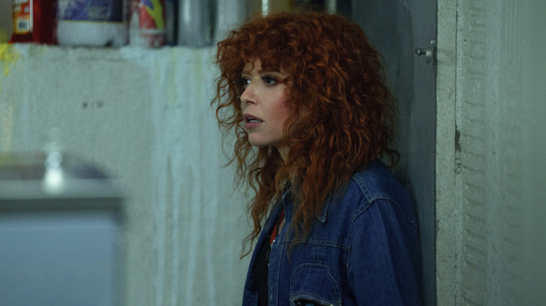 Charlie Cale stands against the door in a dingy apartment laundry room in Poker Face season 2