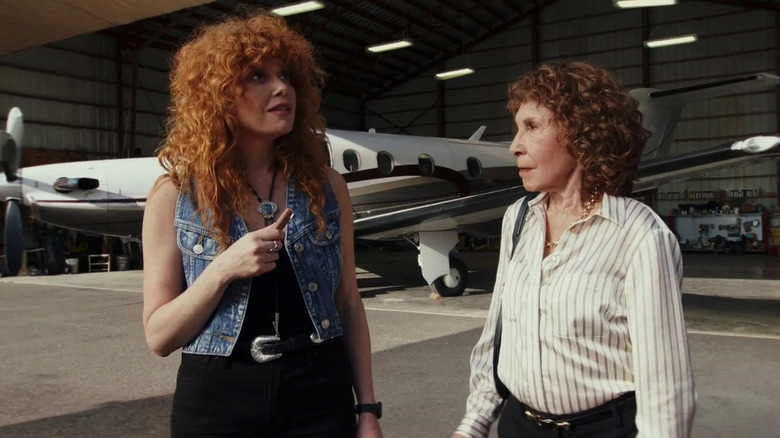 Charlie and Beatrix Hasp standing outside on a plane runway in Poker Face season 2