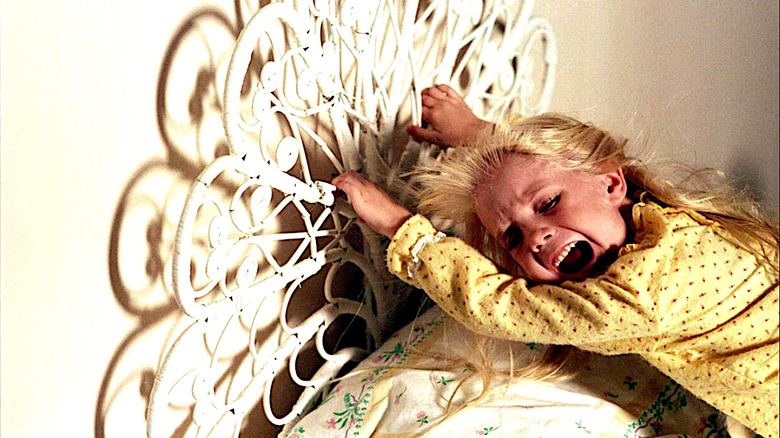 Carol Anne Hangs Onto the Bed Frame and Screams