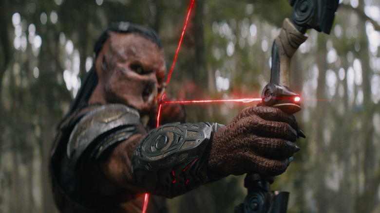 Dek drawing a laser bow to fire in the jungle in Predator: Badlands