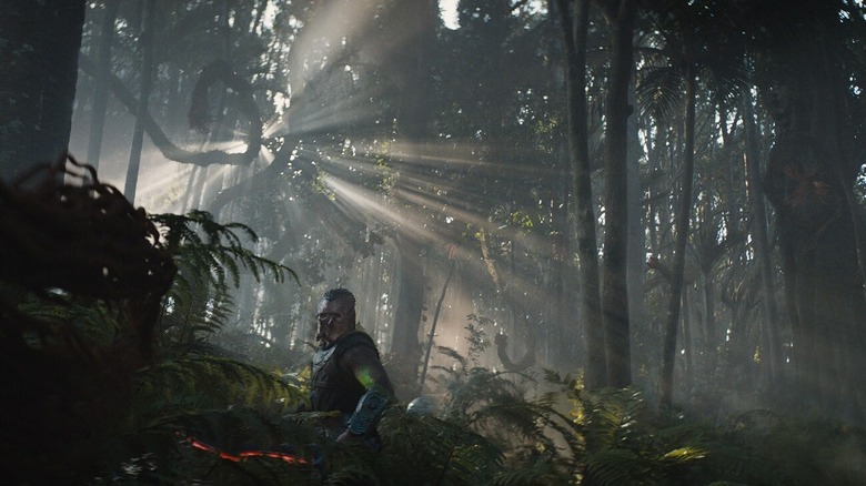 Dek cutting through a lush jungle landscape as light pokes through the leaves above in Predator: Badlands