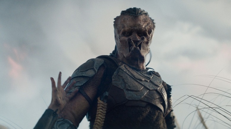 Dimitrius Schuster-Koloamatangi as Dek standing in a field in Predator: Badlands