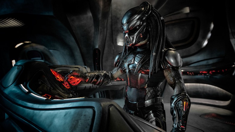 The Predator standing at the control panel of its spaceship in The Predator (2018)