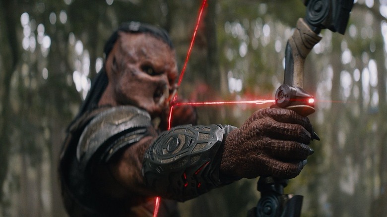 Dimitrius Schuster-Koloamatangi as Dek holding and testing his bow in Predator: Badlands