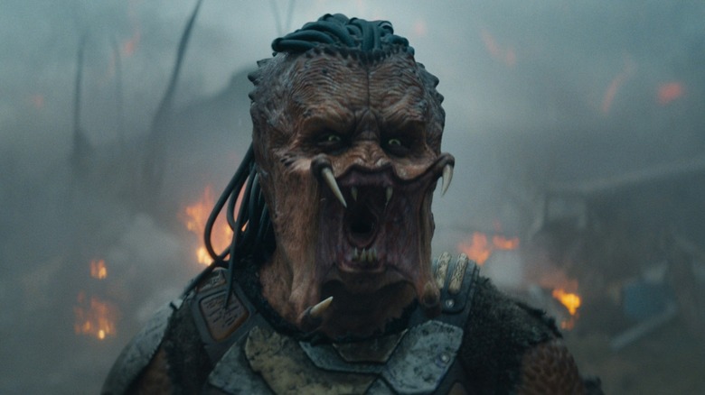 Dimitrius Schuster-Koloamatangi as Dek yelling in front of flaming wreckage in Predator: Badlands