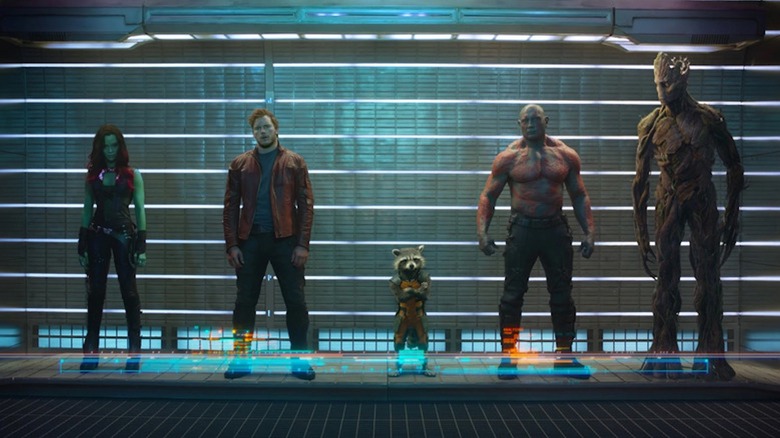 Zoe Saldaña as Gamora, Chris Pratt as Peter Quill, Bradley Cooper as Rocket Raccoon, Dave Bautista as Drax, and Vin Diesel as Groot stand in a lineup in Guardians of the Galaxy