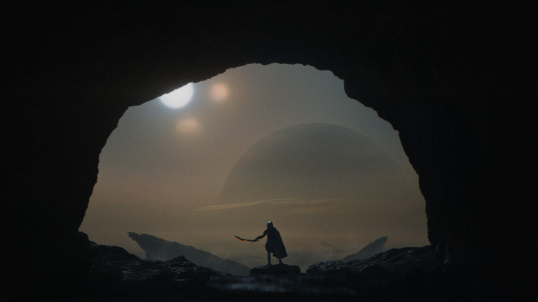 Dek brandishing his plasma sword outside a cave on Yautja Prime in Predator: Badlands