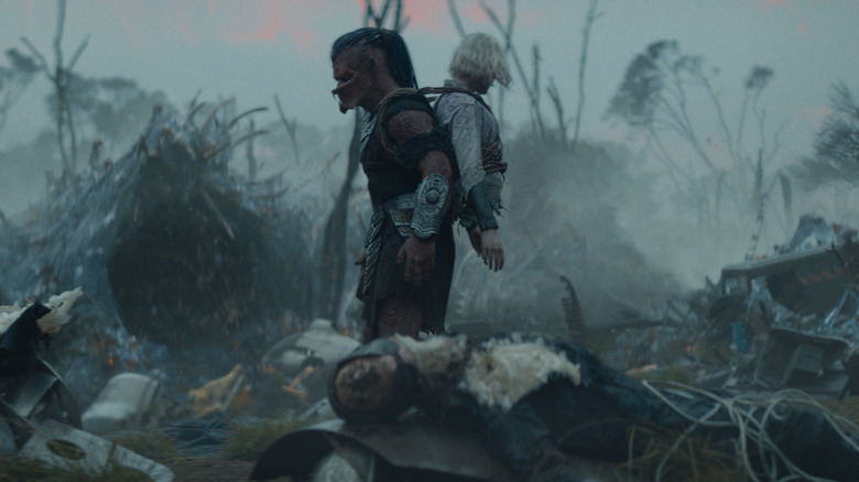 Thia and Dek walking through a decimated Weyland-Yutani camp on Genna in Predator: Badlands