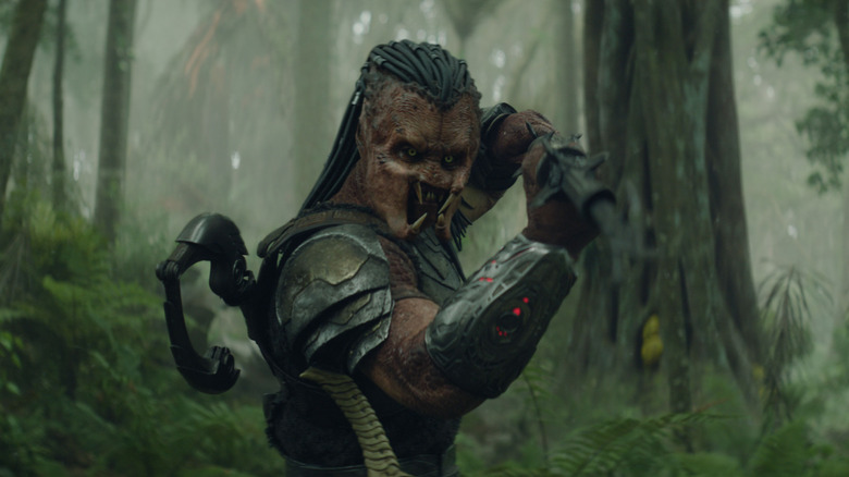 Dimitrius Schuster-Koloamatangi as Dek wielding a sword in the middle of a forest in Predator: Badlands