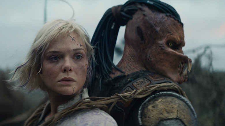 Elle Fanning as Thia riding on Dek's back in Predator: Badlands