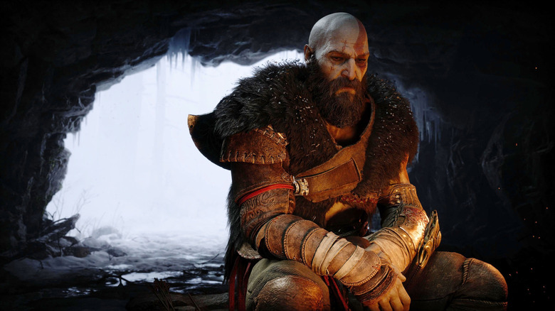 Christopher Judge as the voice of Kratos sitting in a cave by a campfire in God of War Ragnarök