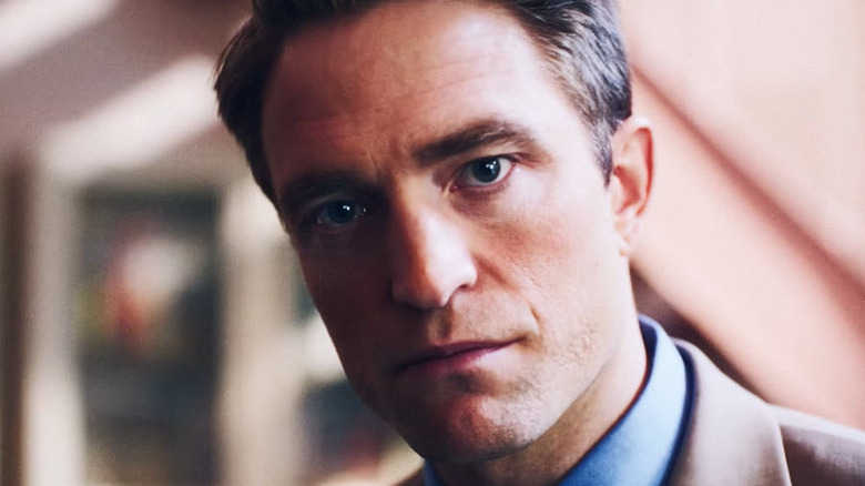 Robert Pattinson's Chris Hansen is seen looking into camera as he stands in a living room in Primetime