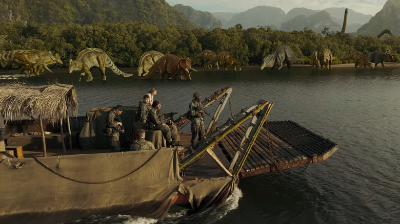 The soldiers looking at dinosaurs on the shoreline from their boat in Primitive War