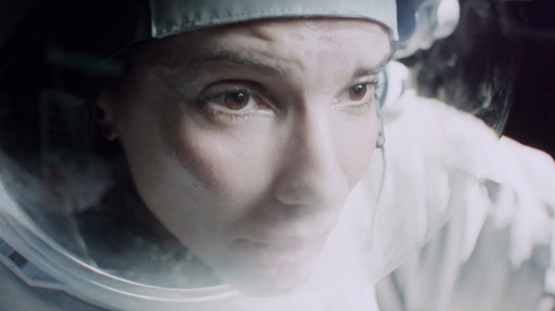 Sandra Bullock's Dr. Ryan Stone is seen in extreme closeup through the visor of her helmet in Gravity