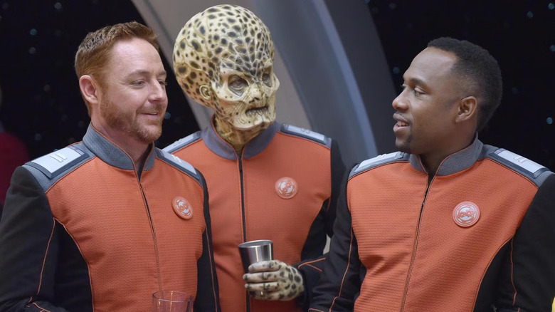 Lieutenants Gordon Malloy and John LaMarr flanking a big-headed alien on The Orville