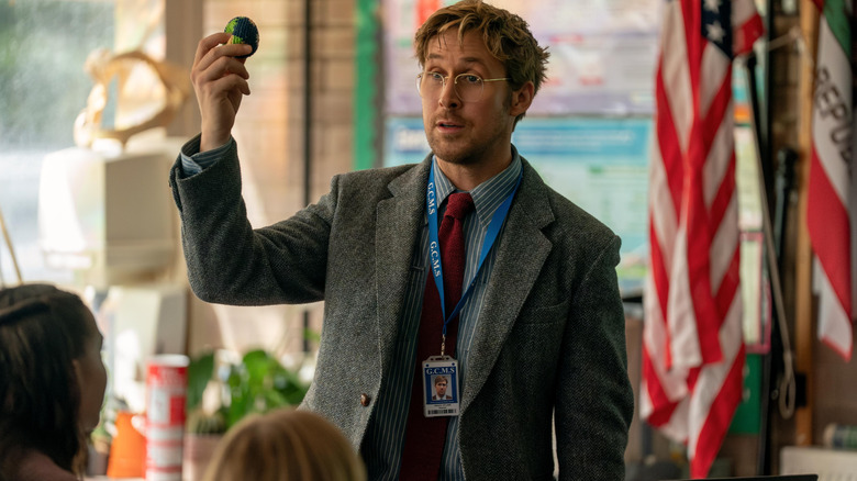 Ryan Gosling as Ryland Grace teaching a class of students and holding up a ball shaped like Earth in Project Hail Mary