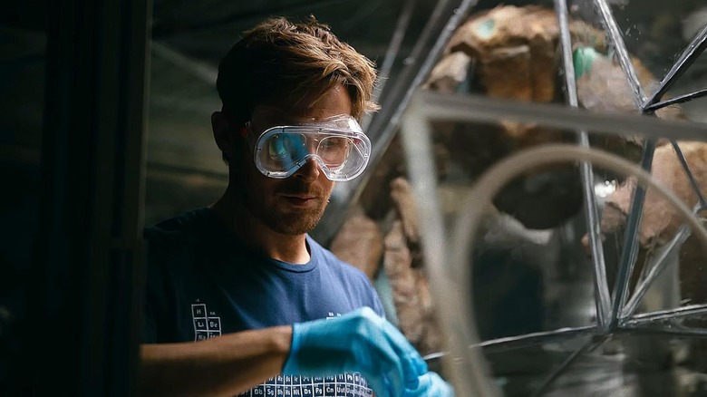 Ryan Gosling as Ryland Grace wearing goggles next to Rocky in Project Hail Mary