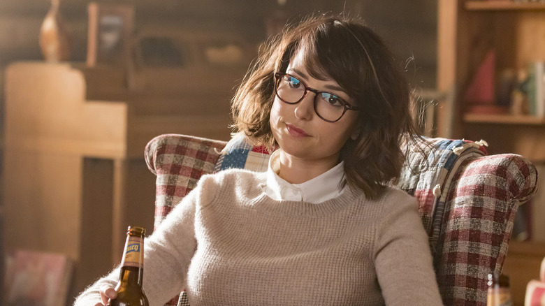 Milana Vayntrub as Sloane sitting in a chair with a beer in the This Is Us episode The Trip