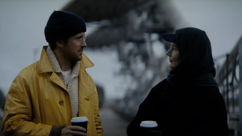 Ryan Gosling as Ryland Grace drinking coffee outside with Sandra Huller as Eva Stratt in Project Hail Mary