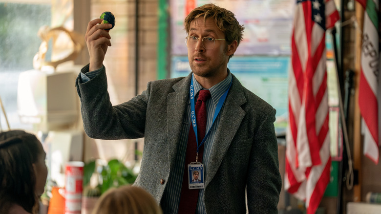 Ryan Gosling as Ryland Grace holding up a yarn ball version of Earth in Project Hail Mary