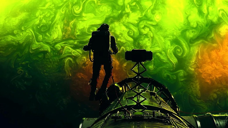 Grace in space above the green glow of planet Adrian in Project Hail Mary