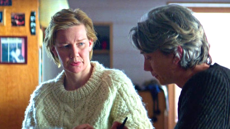 Sandra in a comfy sweater, looking at a grey-haired man in Anatomy of a Fall