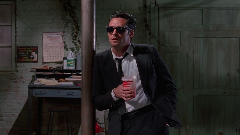 Michael Madsen as Mr. Blonde holding a soda cup in the warehouse in Reservoir Dogs