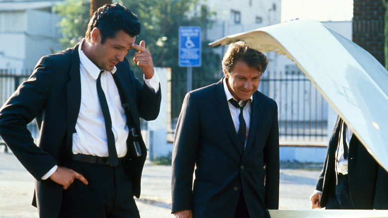 Michael Madsen como Sr. Blonde e Harvey Keitel como Sr. White olhando no porta -malas em cães do reservatório