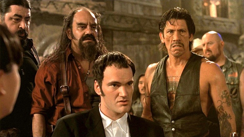 Quentin Tarantino as Richard Gecko surrounded by angry patrons of the bar in From Dusk Till Dawn