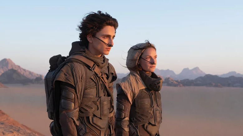 Timothée Chalamet as Paul and Rebecca Ferguson as Lady Jessica standing in the desert in Dune