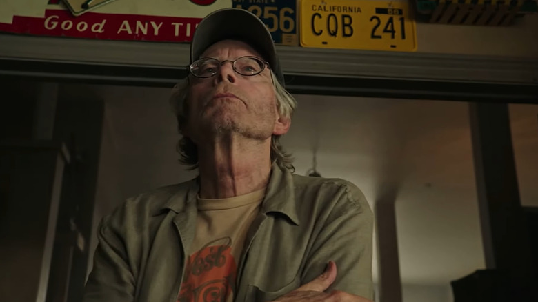 Stephen King as a pawn shop owner with his arms crossed in It: Chapter Two