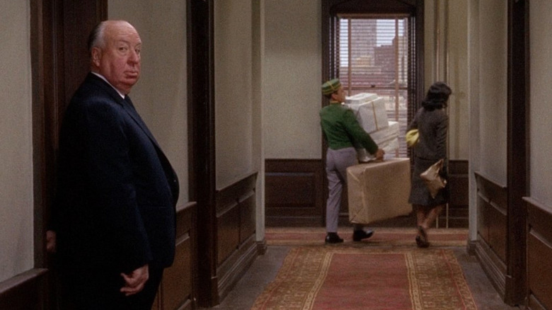 Alfred Hitchcock looking at the camera in a hallway in Marnie