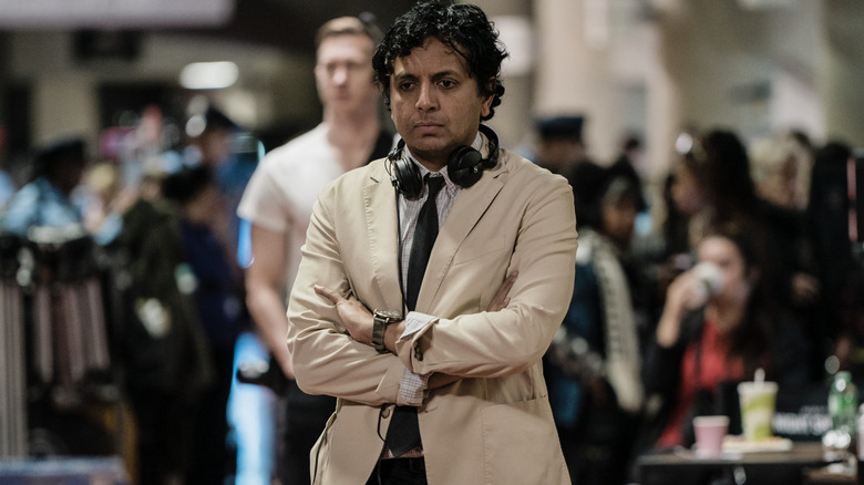 M. Night Shyamalan standing in the middle of several crew members on the set of Trap