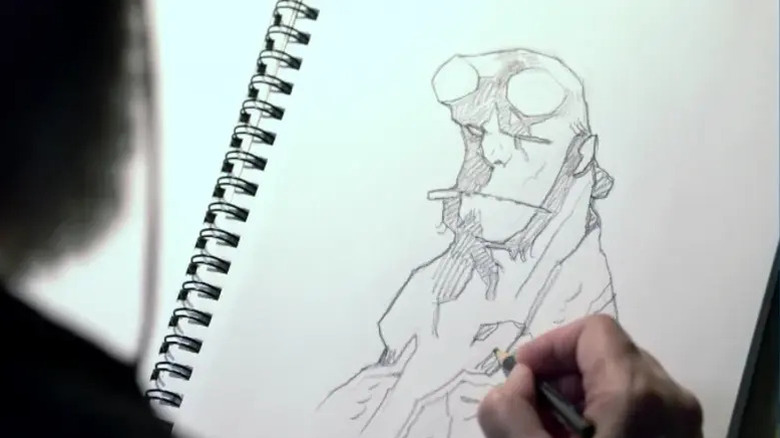 Photograph of Mike Mignola sketching Hellboy's face