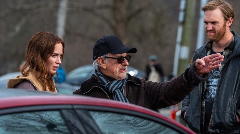 Director Steven Spielberg gesturing to Emily Blunt as Margaret Fairchild and Wyatt Russell as Jackson on the set of Disclosure Day