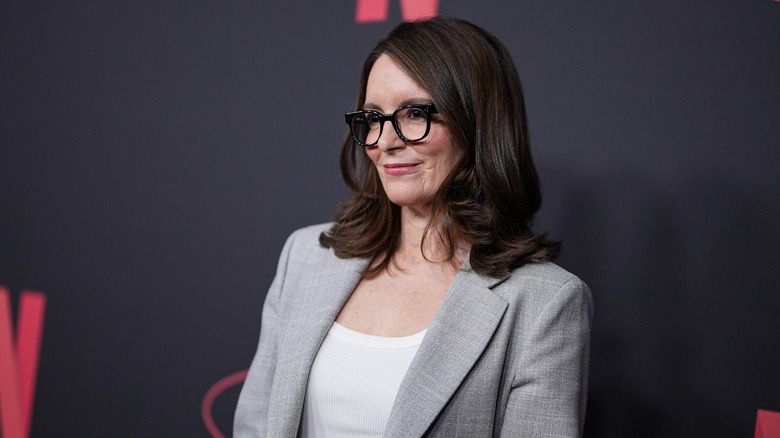 Tina Fey wearing glasses and a gray blazer