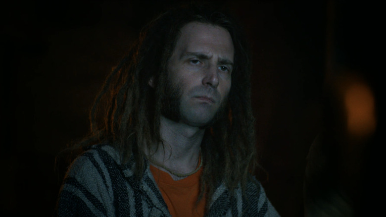 Kyle Mooney's Garrett stands in the dark in Y2K