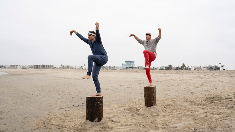 Daniel dan Johnny melakukan tendangan derek di pantai di Cobra Kai