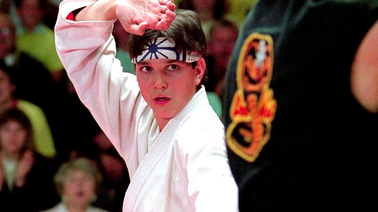 Ralph Macchio as Daniel LaRusso in The Karate Kid, facing off against Johnny Lawrence in a tournament