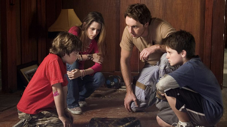 Danny, Lisa, the Astronaut and Walter crouching around the game